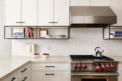 Inspiration for a mid-sized transitional l-shaped enclosed kitchen remodel in Toronto with recessed-panel cabinets, white cabinets, quartzite countertops, white backsplash, ceramic backsplash, stainless steel appliances and a peninsula