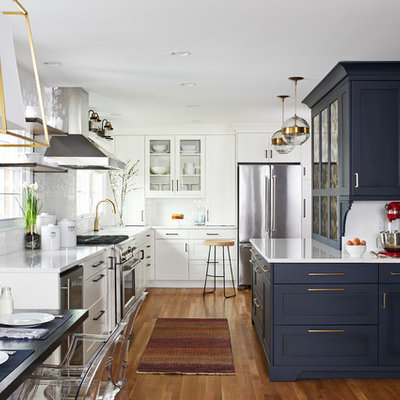 Eat-in kitchen - mid-sized transitional l-shaped medium tone wood floor and brown floor eat-in kitchen idea with shaker cabinets, blue cabinets, white backsplash, subway tile backsplash, quartz countertops, stainless steel appliances, a peninsula, white countertops and a single-bowl sink