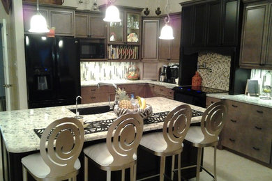Mittelgroße Moderne Küche mit Schrankfronten mit vertiefter Füllung, schwarzen Schränken, Granit-Arbeitsplatte, bunter Rückwand, Rückwand aus Mosaikfliesen, schwarzen Elektrogeräten, Kücheninsel und grauem Boden in Tampa