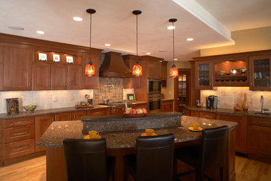 Example of a classic eat-in kitchen design in Milwaukee with an undermount sink, recessed-panel cabinets, medium tone wood cabinets, quartzite countertops, beige backsplash, ceramic backsplash and stainless steel appliances