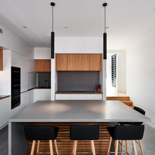 Design ideas for a contemporary l-shaped kitchen in Sydney with a double-bowl sink, flat-panel cabinets, white cabinets, grey splashback, with island, grey floor and grey benchtop.