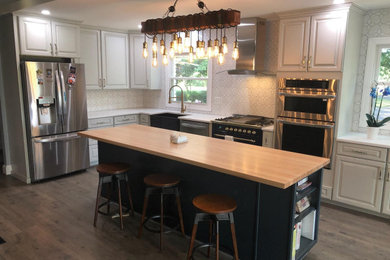 Inspiration for a mid-sized transitional l-shaped kitchen remodel in DC Metro with raised-panel cabinets, gray cabinets and an island