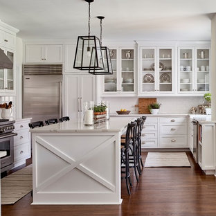 Immagine di una cucina a L country con ante in stile shaker, ante bianche, paraspruzzi bianco, paraspruzzi con piastrelle diamantate, elettrodomestici in acciaio inossidabile, parquet scuro, isola e pavimento marrone