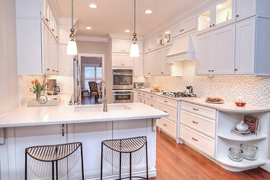 Example of a transitional dark wood floor enclosed kitchen design in Charlotte with an undermount sink, beaded inset cabinets, white cabinets, quartz countertops, white backsplash, mosaic tile backsplash, stainless steel appliances and a peninsula
