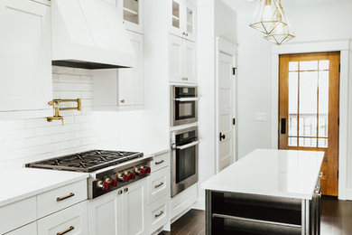 Mid-sized trendy u-shaped dark wood floor and brown floor kitchen pantry photo in Seattle with an undermount sink, recessed-panel cabinets, white cabinets, quartzite countertops, white backsplash, subway tile backsplash, stainless steel appliances, an island and white countertops