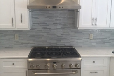 Mid-sized trendy u-shaped eat-in kitchen photo in Miami with a single-bowl sink, shaker cabinets, white cabinets, quartzite countertops, blue backsplash, matchstick tile backsplash and stainless steel appliances