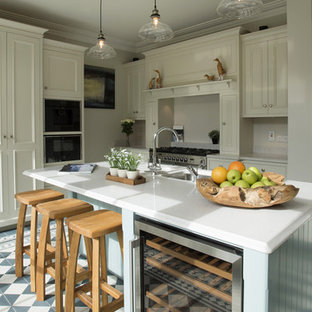 Medium sized rural l-shaped kitchen/diner in Dublin with quartz worktops, ceramic flooring, a submerged sink, shaker cabinets, white cabinets, beige splashback, stone slab splashback, stainless steel appliances, a breakfast bar and multi-coloured floors.