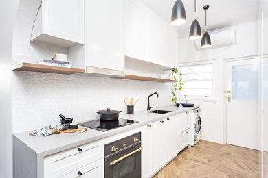 Inspiration for a small scandinavian galley kitchen pantry in Sydney with a submerged sink, shaker cabinets, white cabinets, engineered stone countertops, grey splashback, ceramic splashback, black appliances, porcelain flooring, beige floors and grey worktops.