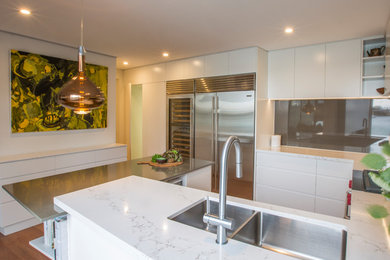 Esempio di una cucina minimal di medie dimensioni con lavello a doppia vasca, top in quarzo composito, paraspruzzi con piastrelle di metallo e elettrodomestici in acciaio inossidabile