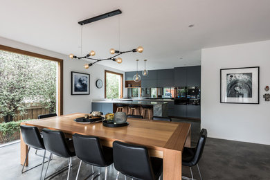 Idee per una grande sala da pranzo aperta verso la cucina design con pavimento in cemento e pavimento grigio