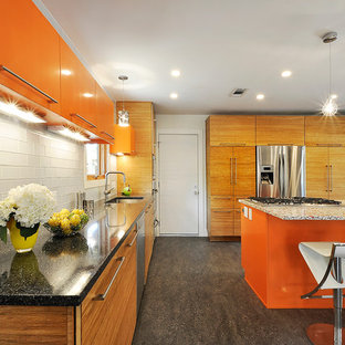 Inspiration for an eclectic kitchen in Austin with an undermount sink, flat-panel cabinets, orange cabinets, white splashback, glass tile splashback and stainless steel appliances.
