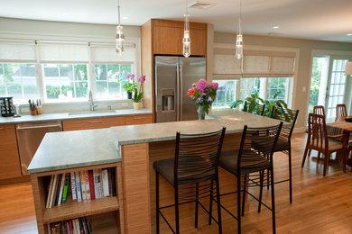 Example of a large trendy u-shaped light wood floor open concept kitchen design in Boston with flat-panel cabinets, medium tone wood cabinets, granite countertops, glass tile backsplash, an island, an undermount sink and stainless steel appliances