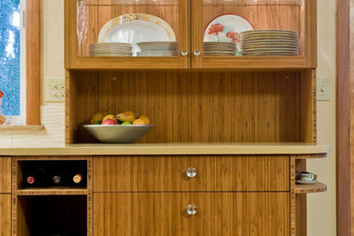 Cette image montre une cuisine américaine linéaire design en bois brun avec un placard à porte plane.