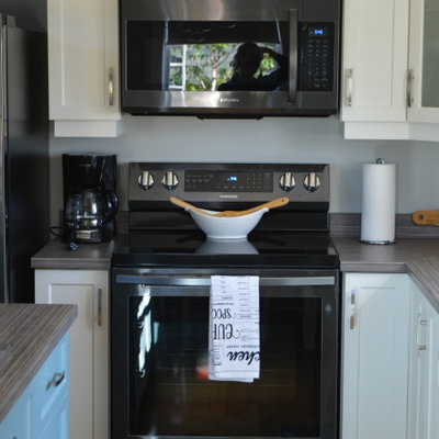 Example of a small beach style l-shaped light wood floor and vaulted ceiling eat-in kitchen design in Other with an island, multicolored countertops and a drop-in sink