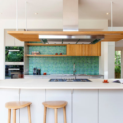 Kitchen - contemporary galley medium tone wood floor and orange floor kitchen idea in Melbourne with flat-panel cabinets, white cabinets, green backsplash, stainless steel appliances and an island