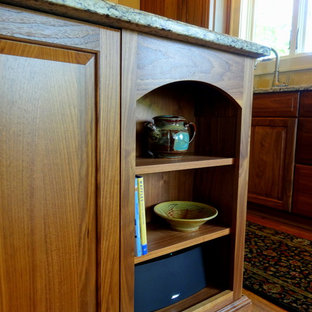 Inspiration for a mid-sized timeless l-shaped medium tone wood floor open concept kitchen remodel in Charlotte with a double-bowl sink, raised-panel cabinets, dark wood cabinets, granite countertops, beige backsplash, ceramic backsplash, stainless steel appliances and an island