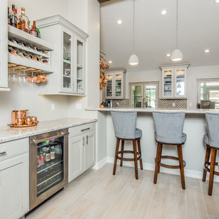 This is an example of a mid-sized transitional galley eat-in kitchen in San Diego with an undermount sink, shaker cabinets, beige cabinets, granite benchtops, beige splashback, porcelain splashback, stainless steel appliances, light hardwood floors and beige floor.