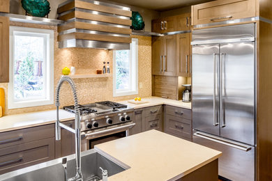 Example of a mid-sized transitional u-shaped medium tone wood floor and brown floor enclosed kitchen design in Other with a single-bowl sink, shaker cabinets, gray cabinets, quartzite countertops, beige backsplash, mosaic tile backsplash, stainless steel appliances and an island