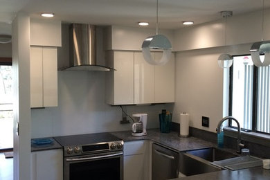 Medium sized modern u-shaped enclosed kitchen in Hawaii with a belfast sink, flat-panel cabinets, white cabinets, concrete worktops, grey splashback, stainless steel appliances and porcelain flooring.