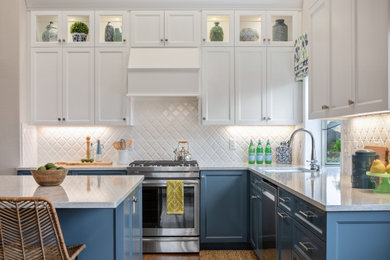Inspiration for a mid-sized transitional u-shaped dark wood floor and brown floor open concept kitchen remodel in Portland with an undermount sink, shaker cabinets, blue cabinets, quartzite countertops, white backsplash, porcelain backsplash, stainless steel appliances, an island and white countertops