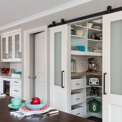 Example of a small transitional dark wood floor and brown floor kitchen pantry design in Detroit with shaker cabinets, white cabinets, white backsplash, subway tile backsplash, stainless steel appliances, an island, a farmhouse sink, wood countertops and white countertops