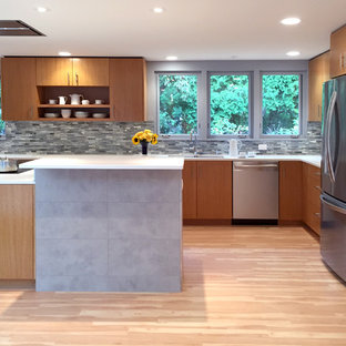 This is an example of a mid-sized midcentury u-shaped kitchen in Milwaukee with a double-bowl sink, open cabinets, medium wood cabinets, quartz benchtops, grey splashback, glass tile splashback, stainless steel appliances, vinyl floors and with island.