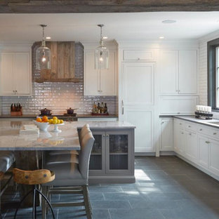 Inspiration for a mid-sized country eat-in kitchen in Chicago with a drop-in sink, recessed-panel cabinets, white cabinets, marble benchtops, white splashback, ceramic splashback, stainless steel appliances, porcelain floors, multiple islands and brown floor.