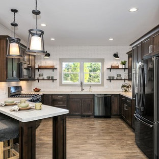 Traditional u-shaped open plan kitchen in Grand Rapids with a double-bowl sink, louvered cabinets, dark wood cabinets, laminate benchtops, white splashback, subway tile splashback, stainless steel appliances, laminate floors and beige benchtop.