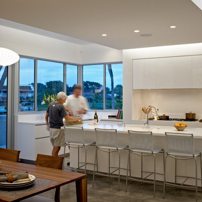 Minimalist eat-in kitchen photo in Other with flat-panel cabinets, white cabinets and white backsplash