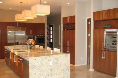 Modern inredning av ett stort kök, med en rustik diskho, släta luckor, skåp i mellenmörkt trä, granitbänkskiva, rostfria vitvaror, en köksö, beiget golv och klinkergolv i porslin