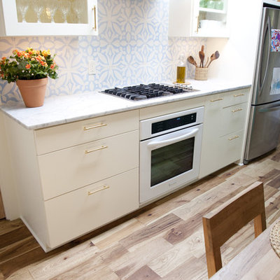 Inspiration for a mediterranean kitchen remodel in Austin with glass-front cabinets, marble countertops and white appliances