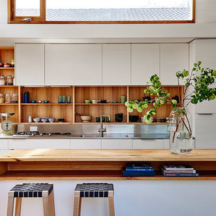 Inspiration for a beach style kitchen in Geelong with an integrated sink, open cabinets, light wood cabinets, stainless steel benchtops, metallic splashback and with island.