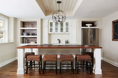 Eat-in kitchen - large transitional medium tone wood floor eat-in kitchen idea in Minneapolis with beaded inset cabinets, white cabinets, wood countertops, white backsplash, an island, a farmhouse sink, porcelain backsplash and stainless steel appliances