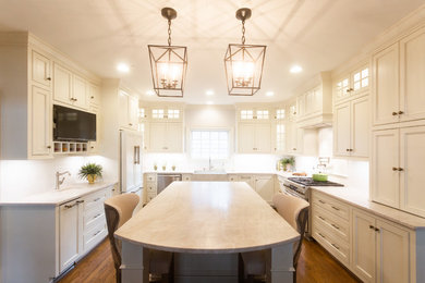 Large elegant u-shaped medium tone wood floor and brown floor eat-in kitchen photo in Little Rock with a farmhouse sink, beaded inset cabinets, white cabinets, quartzite countertops, ceramic backsplash, paneled appliances, an island and beige countertops