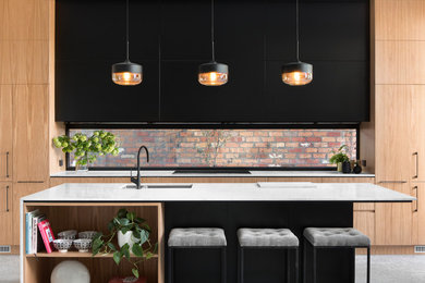 Moderne Küche mit Doppelwaschbecken, flächenbündigen Schrankfronten, hellen Holzschränken und Kücheninsel in Melbourne