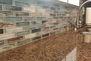 Inspiration for a contemporary kitchen remodel in Indianapolis with glass tile backsplash and an island