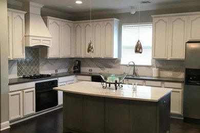 This is an example of a large traditional l-shaped open plan kitchen in Dallas with a double-bowl sink, recessed-panel cabinets, white cabinets, grey splashback, ceramic splashback, stainless steel appliances, dark hardwood flooring and an island.