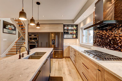 Inspiration for a large contemporary l-shaped light wood floor and beige floor open concept kitchen remodel in Toronto with a drop-in sink, flat-panel cabinets, light wood cabinets, solid surface countertops, metallic backsplash, metal backsplash, stainless steel appliances and an island