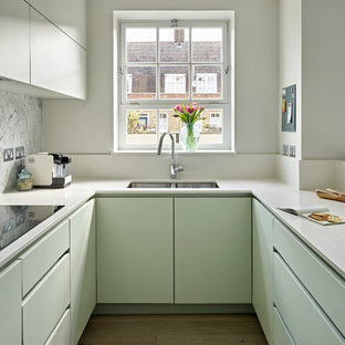 Idee per una piccola cucina ad U design con lavello a doppia vasca, ante lisce, ante verdi, paraspruzzi multicolore, paraspruzzi in marmo, parquet chiaro, nessuna isola, pavimento beige e top bianco