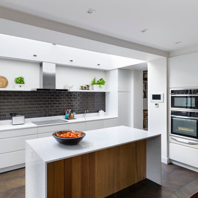 Inspiration for a contemporary l-shaped dark wood floor eat-in kitchen remodel in London with flat-panel cabinets, black backsplash, stainless steel appliances and an island