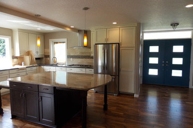 Example of a large transitional l-shaped dark wood floor open concept kitchen design in Portland with an undermount sink, shaker cabinets, white cabinets, beige backsplash, mosaic tile backsplash, stainless steel appliances and an island