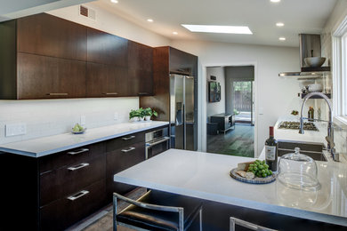 Inspiration for a small contemporary l-shaped dark wood floor eat-in kitchen remodel in San Francisco with a double-bowl sink, flat-panel cabinets, dark wood cabinets, quartz countertops, white backsplash, porcelain backsplash, stainless steel appliances and a peninsula