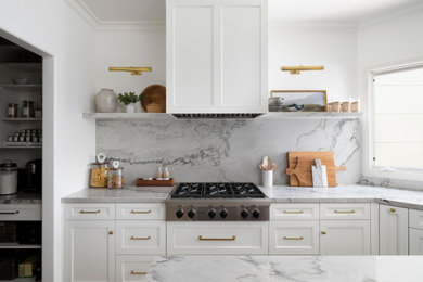 Inspiration for a large traditional u-shaped enclosed kitchen in San Diego with a submerged sink, beaded cabinets, white cabinets, quartz worktops, grey splashback, stone slab splashback, integrated appliances, limestone flooring, an island, beige floors and grey worktops.