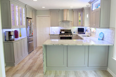 This is an example of a medium sized classic u-shaped open plan kitchen in Nashville with a submerged sink, recessed-panel cabinets, grey cabinets, marble worktops, white splashback, marble splashback, stainless steel appliances, light hardwood flooring, a breakfast bar, beige floors and white worktops.