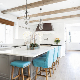 Ispirazione per una grande cucina stile marinaro con lavello stile country, ante in stile shaker, ante bianche, top in marmo, paraspruzzi bianco, elettrodomestici in acciaio inossidabile e parquet chiaro