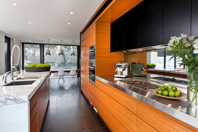 Eat-in kitchen - small modern u-shaped ceramic tile eat-in kitchen idea in Sydney with a drop-in sink, flat-panel cabinets, medium tone wood cabinets, marble countertops, glass sheet backsplash, stainless steel appliances and an island