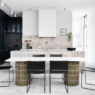 This is an example of a large contemporary l-shaped open plan kitchen in Melbourne with with island, grey floor, black cabinets, beige splashback and beige benchtop.