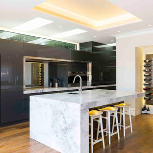 Design ideas for a contemporary kitchen in Sydney with an undermount sink, flat-panel cabinets, grey cabinets, mirror splashback, stainless steel appliances, medium hardwood floors, with island and white benchtop.