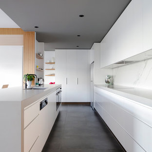 Inspiration for a contemporary kitchen in Sydney with an undermount sink, flat-panel cabinets, white cabinets, white splashback, stone slab splashback, grey floor and grey benchtop.