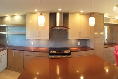 Example of a transitional l-shaped eat-in kitchen design in Tampa with an undermount sink, flat-panel cabinets, beige cabinets, quartz countertops, blue backsplash and stainless steel appliances